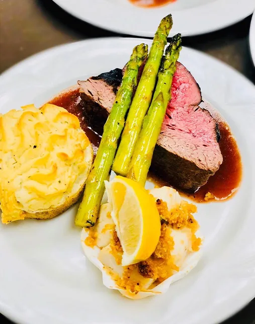 A dinner plate with steak, potatoes, and asparagus