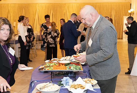 Man and woman getting food from a buffet