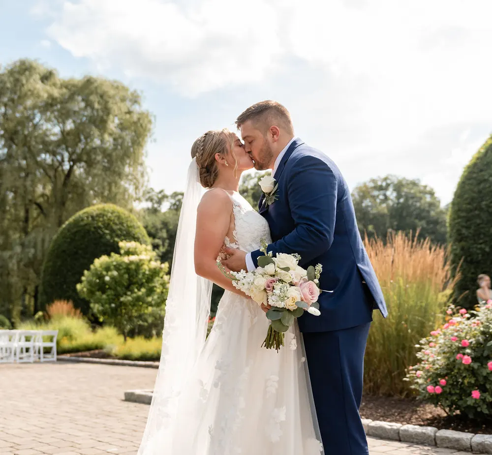 Bride and groom kissing outside